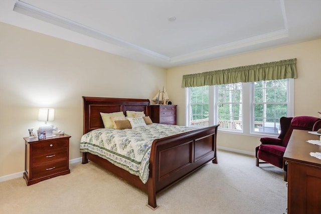 carpeted bedroom featuring a tray ceiling and ornamental molding