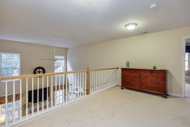 carpeted empty room featuring ceiling fan and a healthy amount of sunlight