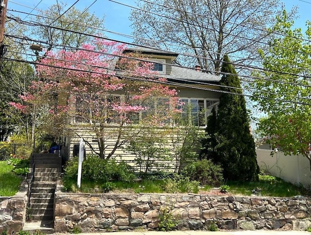 view of property exterior with stairway and fence
