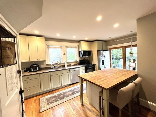 kitchen featuring recessed lighting, light wood-style flooring, appliances with stainless steel finishes, and a sink