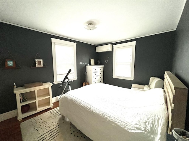 bedroom featuring baseboards, a wall mounted air conditioner, crown molding, and dark wood-type flooring