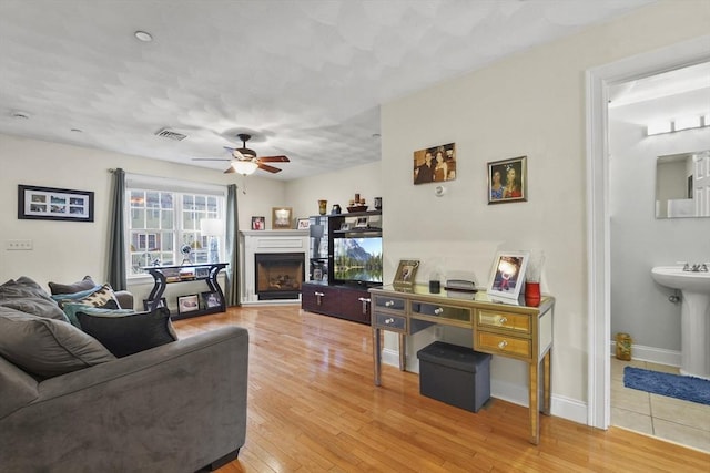5239 N Main St Unit 7, Fall River, MA 02720 - living area with a fireplace, a ceiling fan, light wood-type flooring, and baseboards