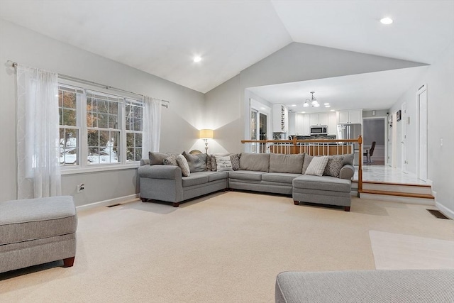 living room with light carpet, visible vents, a chandelier, and lofted ceiling