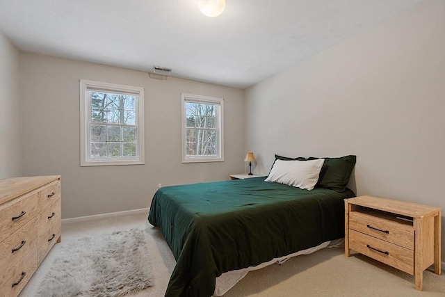 bedroom with light carpet, visible vents, and baseboards