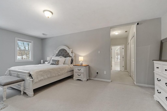 bedroom with baseboards and light colored carpet