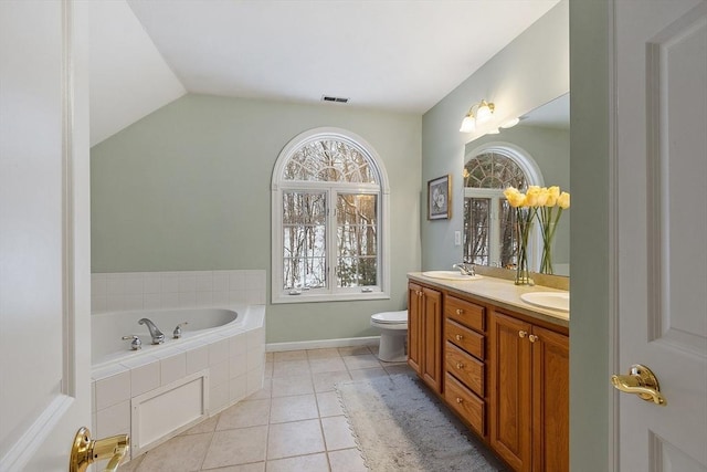 full bathroom featuring double vanity, a sink, tile patterned flooring, vaulted ceiling, and tiled bath