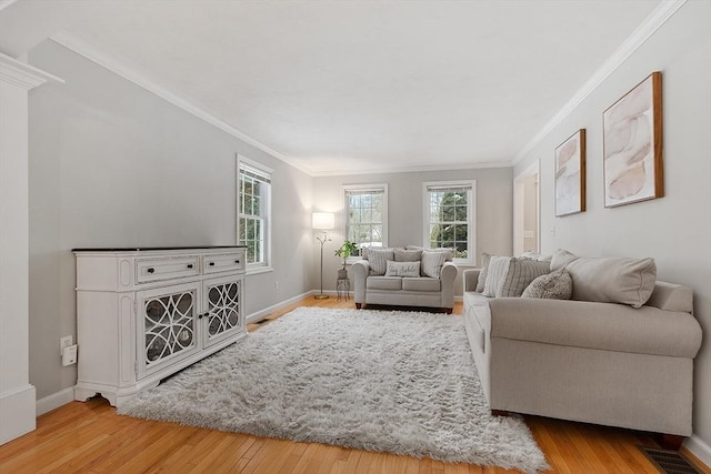 living room with visible vents, baseboards, hardwood / wood-style floors, and crown molding