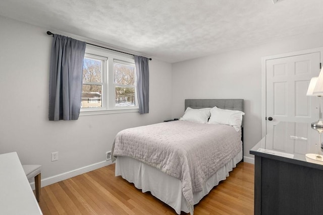 bedroom featuring light wood-type flooring and baseboards