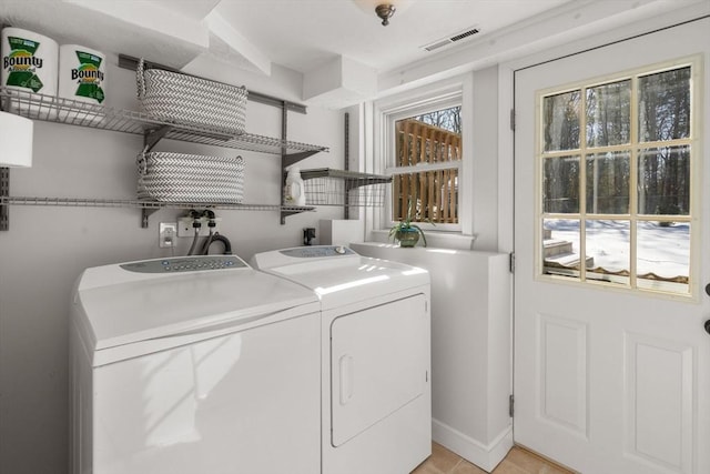 washroom with laundry area, washing machine and clothes dryer, and visible vents