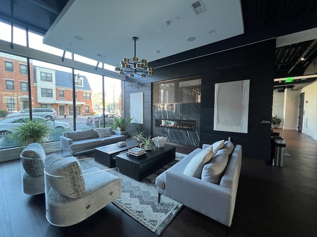 interior space featuring a premium fireplace, dark wood-type flooring, and a notable chandelier