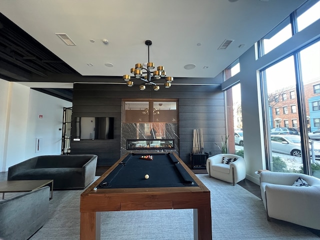 playroom featuring a chandelier, carpet floors, wooden walls, and pool table