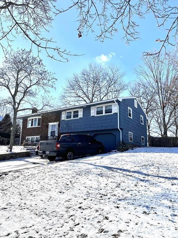 snow covered property featuring a garage