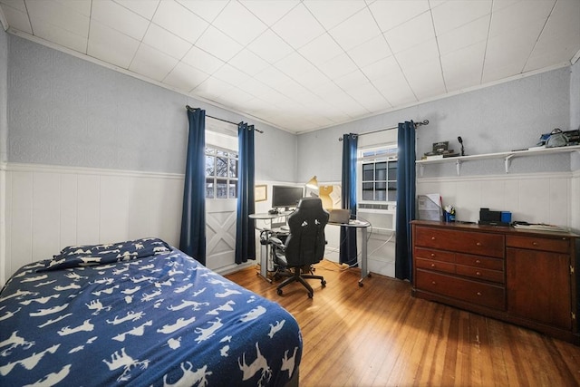 bedroom with crown molding, hardwood / wood-style floors, and multiple windows