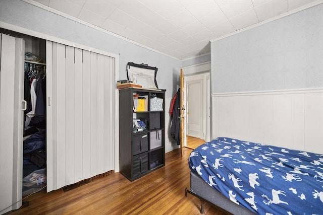 bedroom featuring crown molding, dark hardwood / wood-style flooring, and a closet