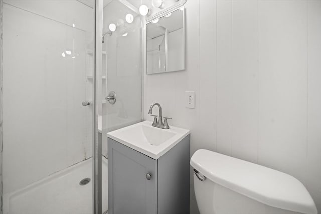 bathroom with vanity, a shower, and toilet