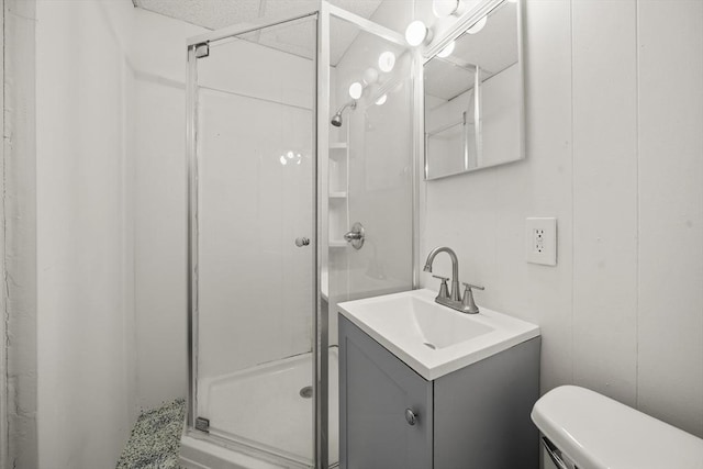 bathroom with a shower with door, vanity, and toilet