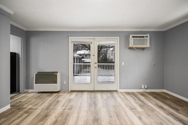 entryway with ornamental molding, a wall mounted AC, and light hardwood / wood-style floors