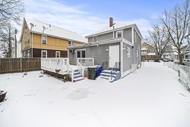 snow covered property featuring a wooden deck