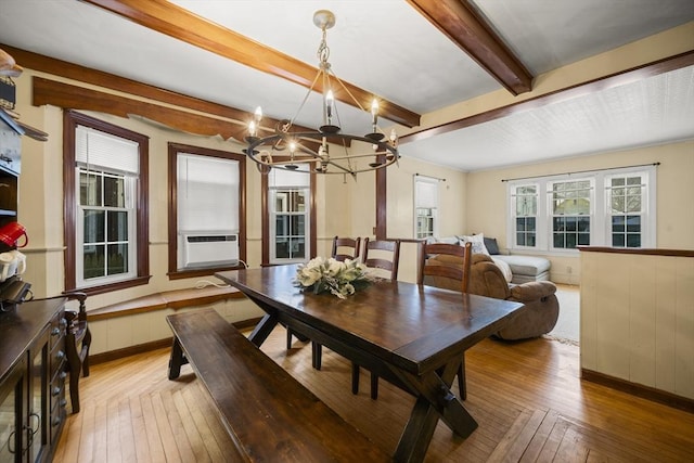 dining room with beamed ceiling, cooling unit, a chandelier, and light hardwood / wood-style flooring