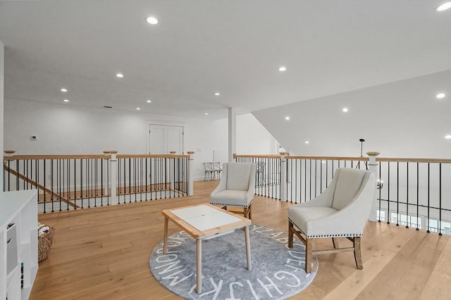 sitting room with lofted ceiling and light wood-type flooring