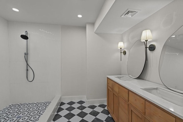 bathroom featuring tiled shower and vanity