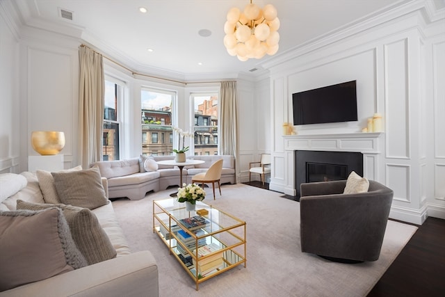 living room featuring ornamental molding, hardwood / wood-style floors, and a notable chandelier