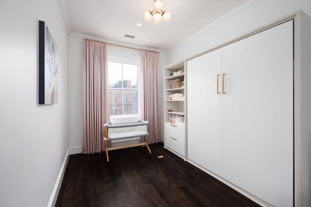 unfurnished bedroom with crown molding, dark wood-type flooring, a notable chandelier, and a closet