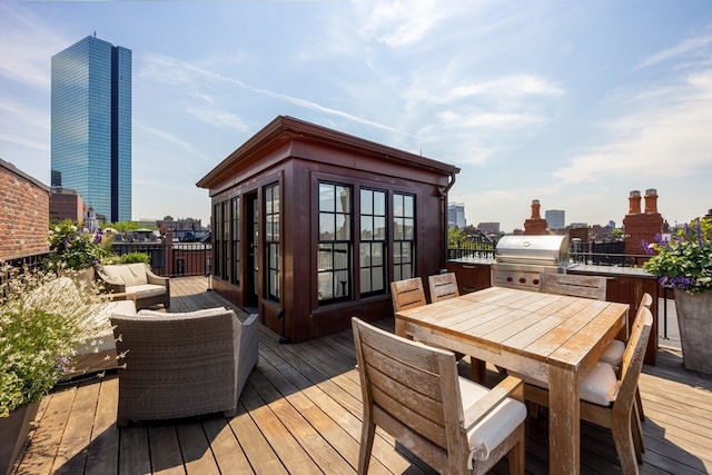 wooden terrace featuring area for grilling and a grill