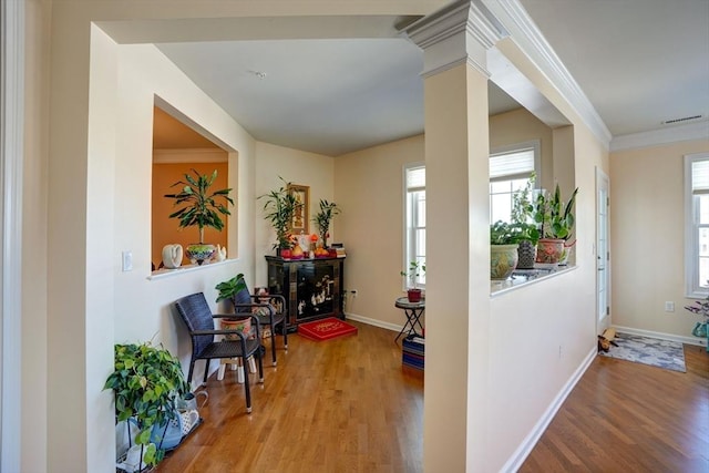 interior space featuring visible vents, plenty of natural light, ornate columns, and wood finished floors