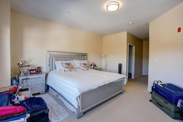 bedroom featuring light carpet and baseboards