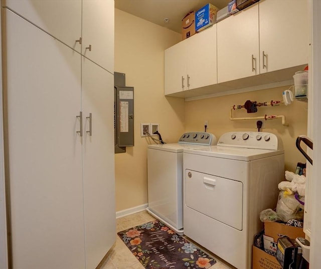 washroom with light tile patterned floors, baseboards, cabinet space, electric panel, and washer and clothes dryer