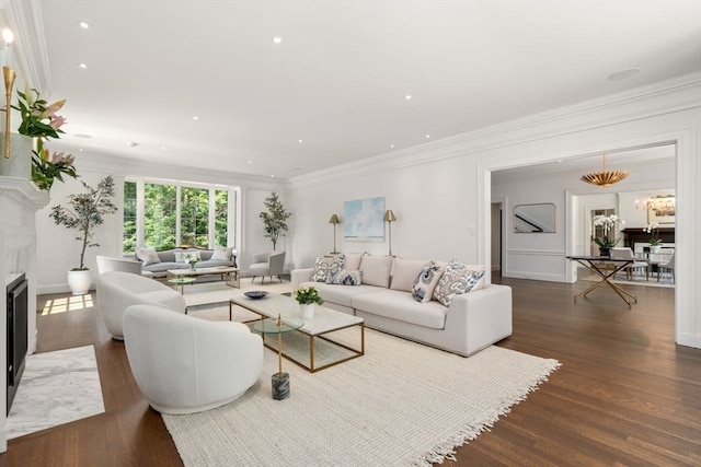 living room with an inviting chandelier, dark hardwood / wood-style flooring, and crown molding