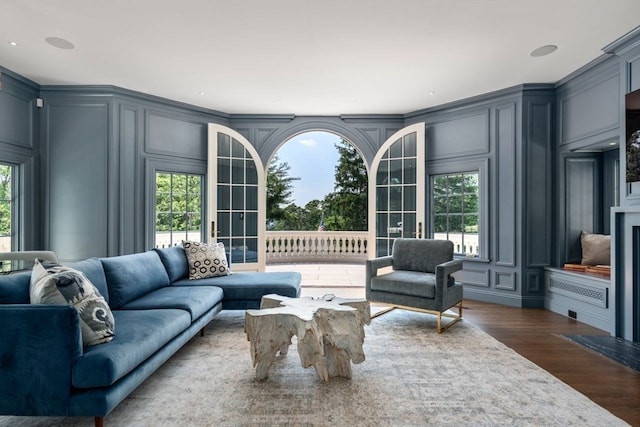 living room featuring ornamental molding, dark hardwood / wood-style flooring, and plenty of natural light