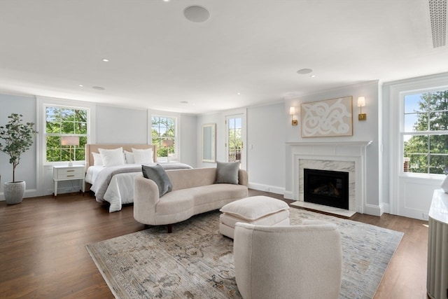 bedroom with a premium fireplace and hardwood / wood-style flooring