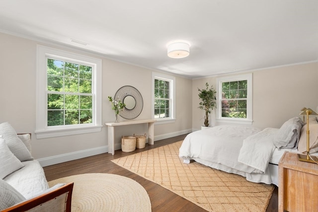 bedroom with ornamental molding, hardwood / wood-style floors, and multiple windows