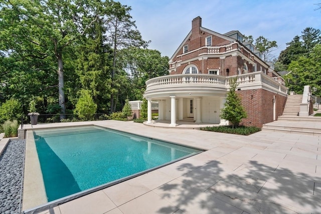 back of property featuring a fenced in pool and a patio area