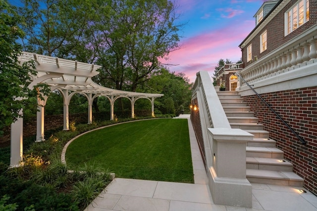 yard at dusk featuring a pergola