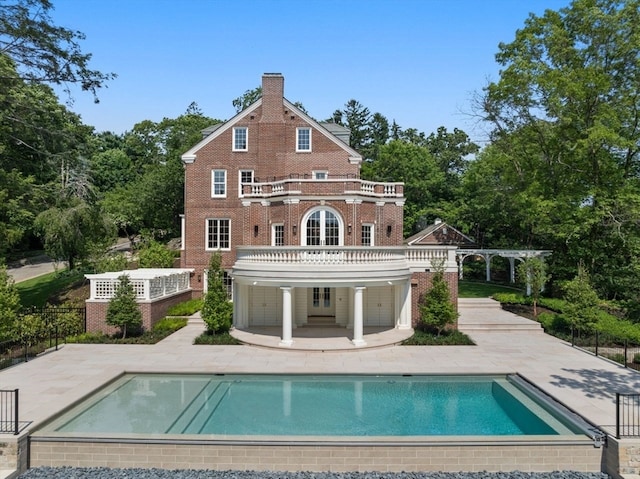 back of house featuring a balcony, a pergola, and a patio area