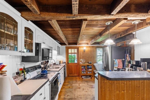 kitchen with appliances with stainless steel finishes, light wood-style flooring, wood ceiling, beam ceiling, and a sink
