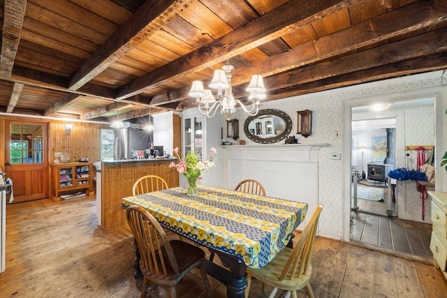 dining area featuring wooden ceiling, wood-type flooring, beamed ceiling, and a chandelier