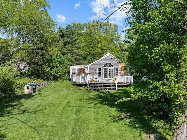 back of property with a lawn and a deck