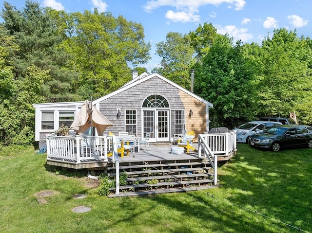 rear view of house featuring a lawn and a deck