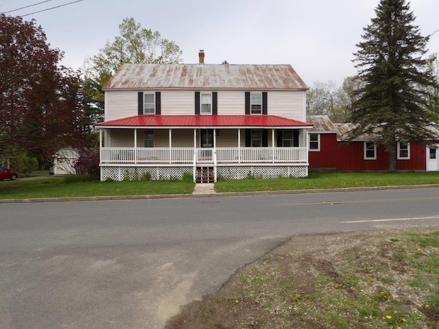 country-style home featuring a front yard and a porch