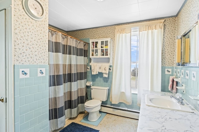 bathroom with a baseboard radiator, toilet, vanity, backsplash, and tile walls