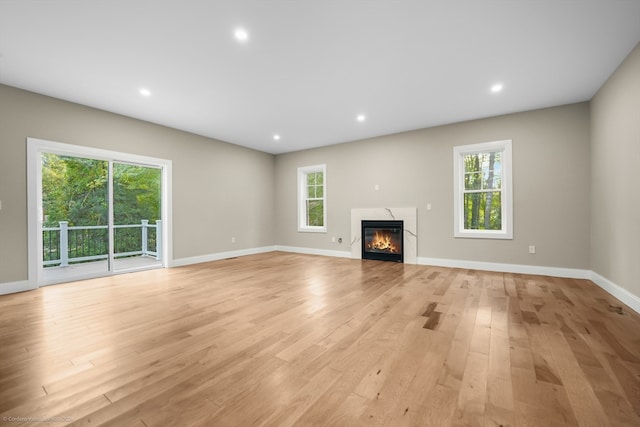 unfurnished living room with light hardwood / wood-style flooring and a wealth of natural light