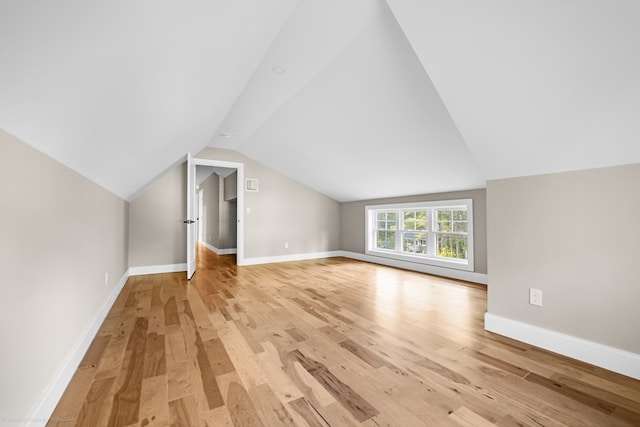 additional living space with light wood-type flooring and lofted ceiling