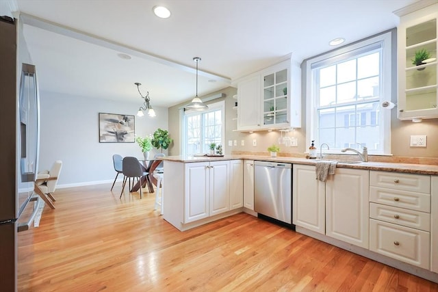 kitchen with decorative light fixtures, light wood-type flooring, stainless steel appliances, and white cabinetry