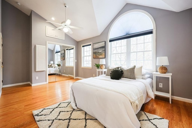 bedroom featuring ceiling fan, light hardwood / wood-style floors, and lofted ceiling