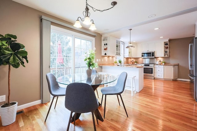 dining space featuring an inviting chandelier and light wood-type flooring