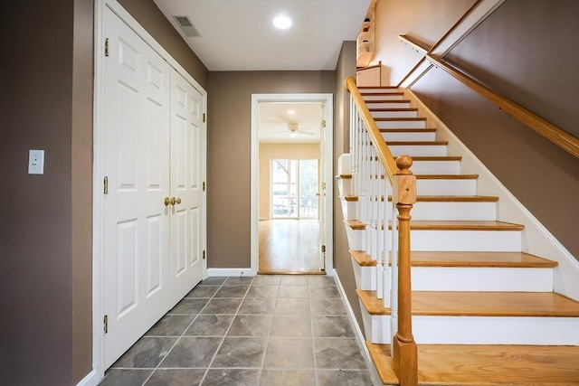 stairs featuring ceiling fan